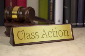 Golden sign with engraved word class action on a desk with gavel